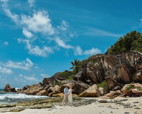 Strandhochzeit La Digue, Grand Anse Brautpaar vor beeindruckender Felsenkulisse Strandhochzeit La Digue, Grand Anse Brautpaar vor beeindruckender Felsenkulisse